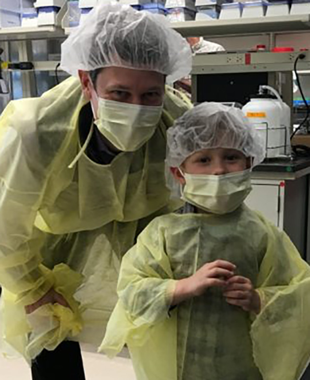 Man and child in scrubs looking at camera