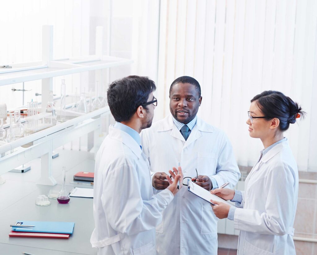 Scientists in lab coats having a discussion in a laboratory